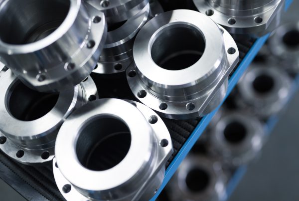 A closeup of thick circular cnc machining fabricated metal pieces with circular cutouts stacked on top of each other