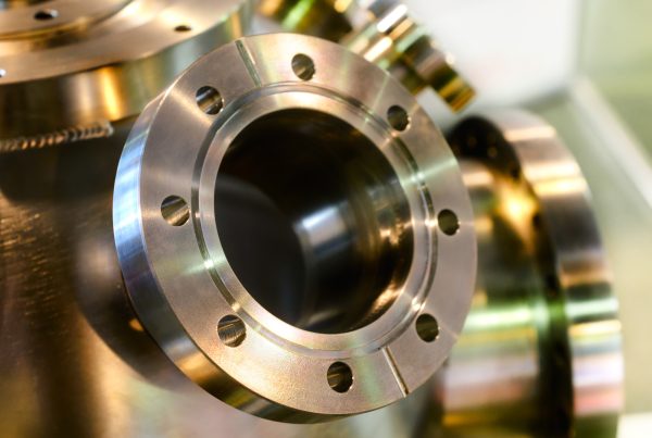Fabricated metal housing with welded flanges produced by machining